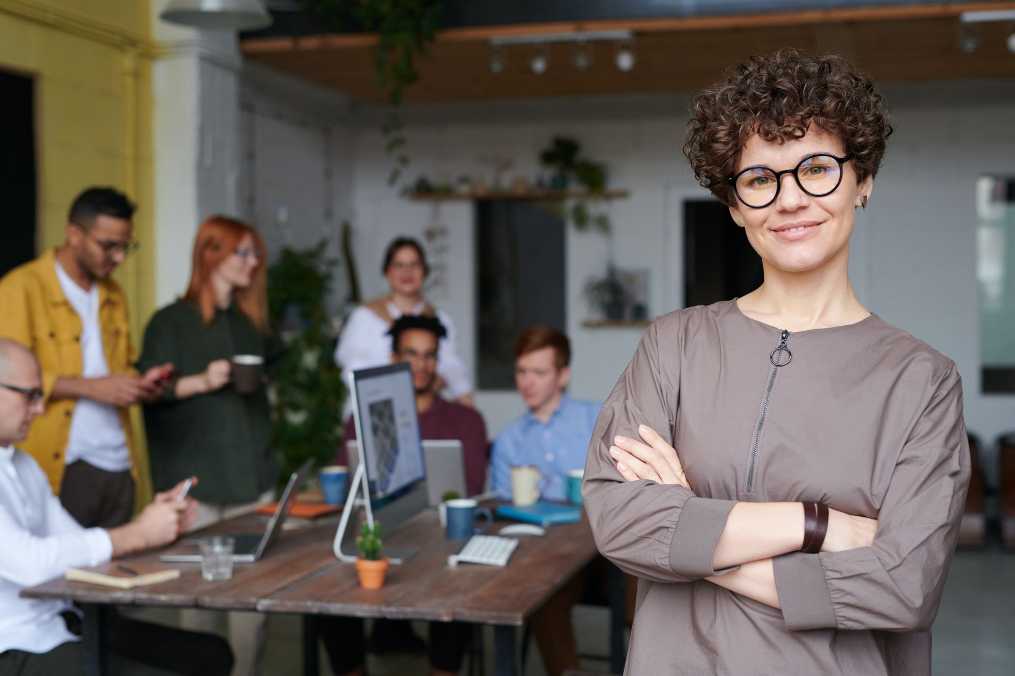 Frau steht im Vordergrund ihres Teams