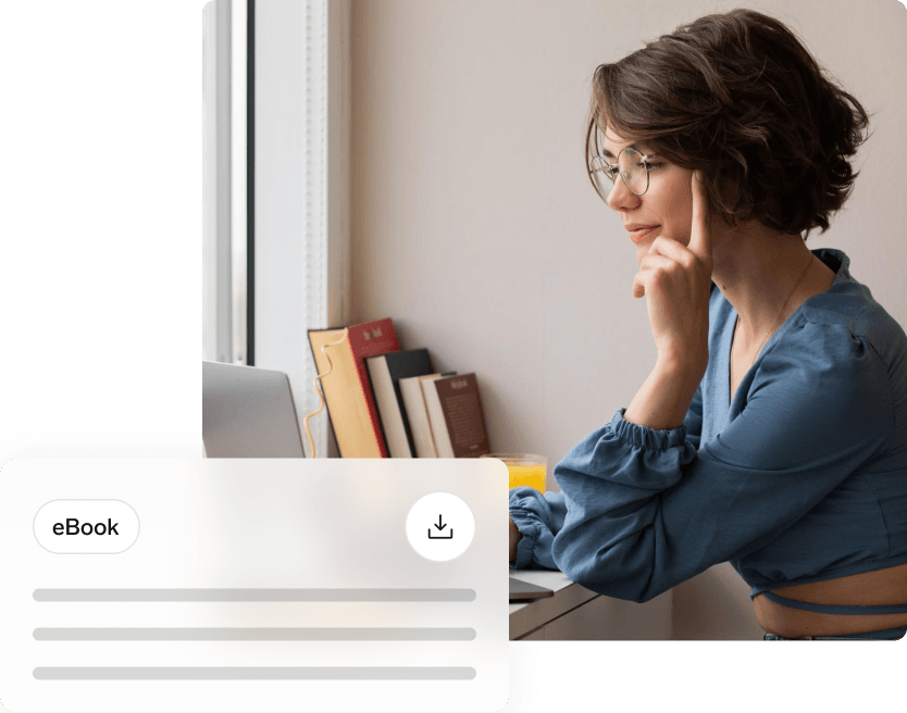 Woman in glasses thoughtfully looking at laptop screen with an ebook download graphic overlay.