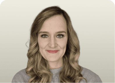 Young woman with long wavy brown hair, light eyes, and a subtle smile.